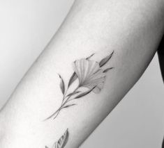 a black and white photo of a woman's arm with a flower tattoo on it