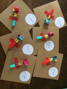 four pieces of craft paper with bows and ribbons on them sitting on top of brown envelopes