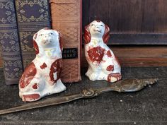 two figurines sitting next to an old book