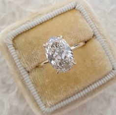 an oval cut diamond ring in a velvet box