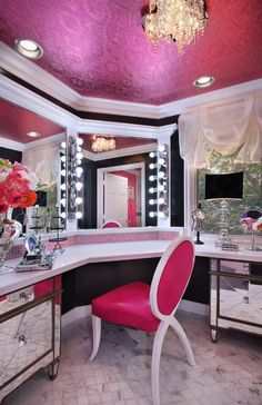 a pink chair sitting in front of a vanity