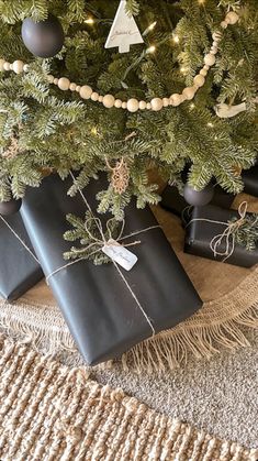 presents wrapped in black paper under a christmas tree