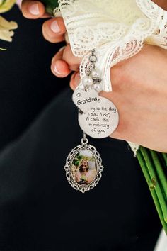 a person holding a bouquet with flowers and a keychain that says grandma on it