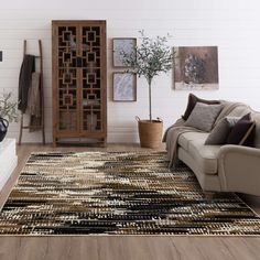 a living room filled with furniture and a rug on top of a hard wood floor