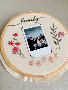 an embroidered photo frame with flowers and family written on it