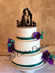 a three tiered wedding cake with purple and green flowers on the side, topped with a silhouette of a bride and groom