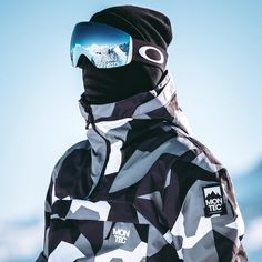 a man wearing a black and white jacket with ski goggles on