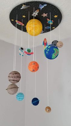 a mobile with planets hanging from it's ceiling in a child's room