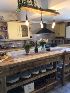 a large kitchen island with pots and pans on it, surrounded by wooden cabinets