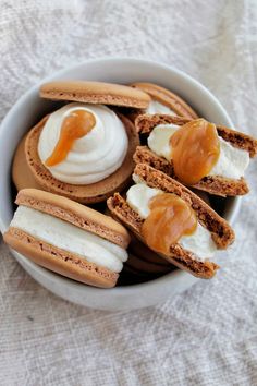 a bowl filled with cookies covered in frosting and caramel on top of each other