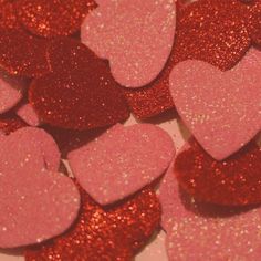 pink and red heart shaped confetti sitting on top of a table