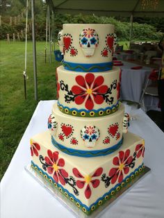 a three tiered cake sitting on top of a white table covered in green grass