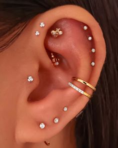 a woman wearing gold ear piercings with small white diamonds on the side of her ear