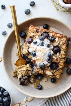 a bowl filled with granola, blueberries and yogurt on top of a table