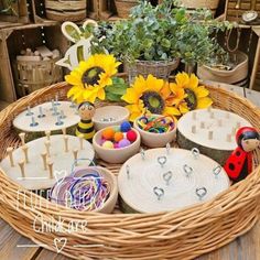 a wicker basket filled with lots of crafting supplies and sunflowers in the background