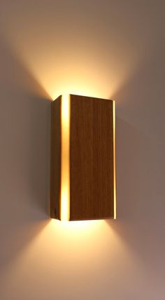 a wooden light fixture mounted to the side of a wall