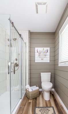 a bathroom with wood floors and gray walls