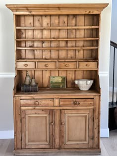 an old wooden hutch with two bowls on top