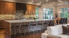 a kitchen and living room are shown in this house's open floor plan, which also features an island with seating for four