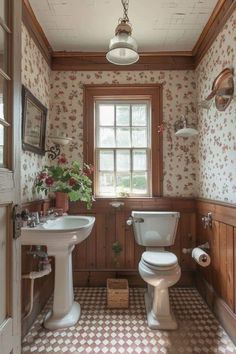 a bathroom with a toilet, sink and mirror next to a window in the wall