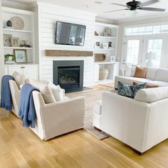 a living room filled with furniture and a flat screen tv mounted on the wall above a fire place