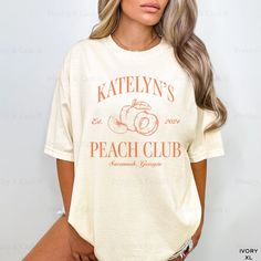 a woman wearing a white t - shirt that says katelyn's peach club