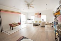 a living room filled with furniture and lots of shelves next to a doorway that leads into another room