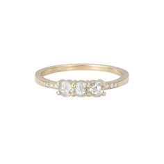 three stone ring in yellow gold with white stones on each side and diamond accenting the band