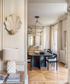 an elegant dining room with wood floors and white walls