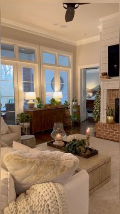 a living room filled with furniture and a fire place in front of two windows next to a fireplace