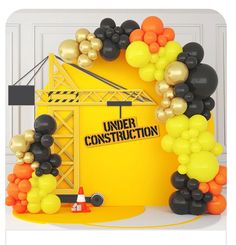 an under construction sign surrounded by balloons