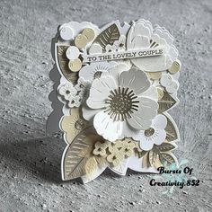 a close up of a card with flowers and leaves on the front, saying to the lovely couple