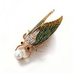 A stylized cicada brooch in four bright enamel colors. Each pin features a cicada holding a simulated pearl. Very elegant and unusual! Standard shipping is free but it does take longer to arrive. It's worth the wait! Specifications: Alloy, enamel, rhinestone, simulated pearl Size: 2.4 x 5.4 cm Origin - China Insect Jewelry Design, Insect Brooch, Weird Jewelry, Insect Jewelry, Botanical Jewelry, Unusual Jewelry, Pearl Size, Animal Jewelry, Pin Brooch