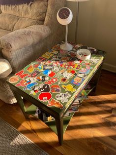 a coffee table with stickers on it sitting in front of a couch and lamp