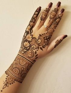 a woman's hand with henna tattoos on it