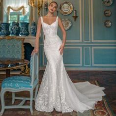 a woman in a white wedding dress standing next to a blue chair and table with plates on it