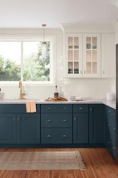 a kitchen with blue cabinets and wooden floors