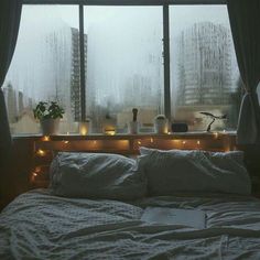 a bed sitting in front of a window covered in rain