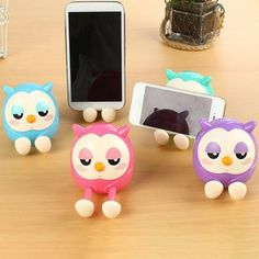 four little owls are standing in front of a cell phone