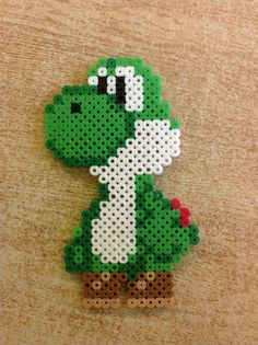 a green and white brooch sitting on top of a wooden table