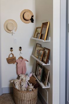 there is a wicker basket with stuffed animals in it and pictures on the wall