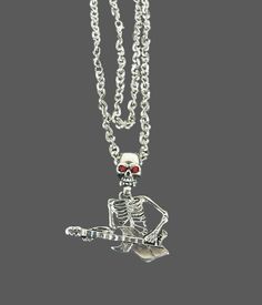 This Vampire Skull Guitar Pendant Necklace is the perfect addition to your Halloween Gothic wardrobe or for any lover of unique retro fashion jewelry. The necklace features a skeleton head in the shape of a guitar adorned with striking red eyes. This is a one-of-a-kind piece that will surely make a statement. The necklace is made with high-quality materials and is new old stock, never used. The skeleton measures approximately 9.5x3cm and weighs around 60 grams. Please note that 1 inch is equival Punk Necklaces For Halloween Concert, Punk Style Necklaces For Halloween Concert, Gothic Necklace For Halloween Concert, Punk Style Jewelry For Halloween Concert, Punk Red Necklace For Halloween, Metal Jewelry For Halloween Concert, Gothic Jewelry For Halloween Concert, Gothic Halloween Jewelry For Concert, Halloween Concert Metal Jewelry