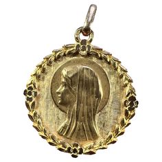 A French 18 karat (18K) yellow gold charm pendant designed as a round medal depicting the Virgin Mary within an engraved frame of leaves and flowers. Stamped with the eagle's head for French manufacture and 18 karat gold, and maker's mark for Perroud. Engraved to the reverse 'Christine' with the date 7-11-69. Dimensions: 2.5 x 2.2 x 0.13 cm (not including jump ring) Weight: 2.95 grams (Chain not included) Mary Flowers, Leaves Wreath, The Virgin Mary, Eagle Head, Leaf Wreath, Gold Medal, Flowers Leaves, Pendant Design, 7 11