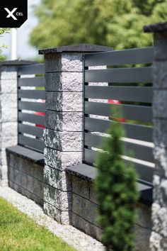 a stone and wood fence in front of some trees