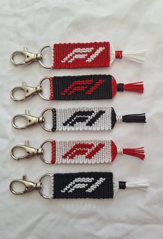 four knitted key fobs with red, white and black designs on them