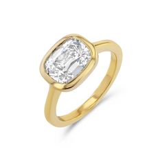 a yellow gold ring with an oval cut diamond in the center, set on a white background