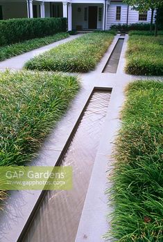 an outdoor garden with grass and water running through it