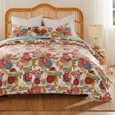 a bed with a floral comforter and pillows