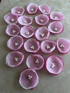 pink and white flowers are arranged on the ground with one flower in the middle, surrounded by smaller ones