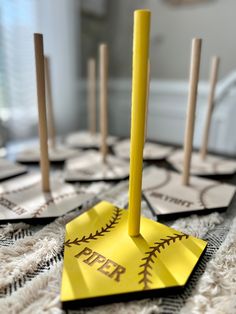 a yellow baseball bat shaped paper on top of a table with wooden dows in the background